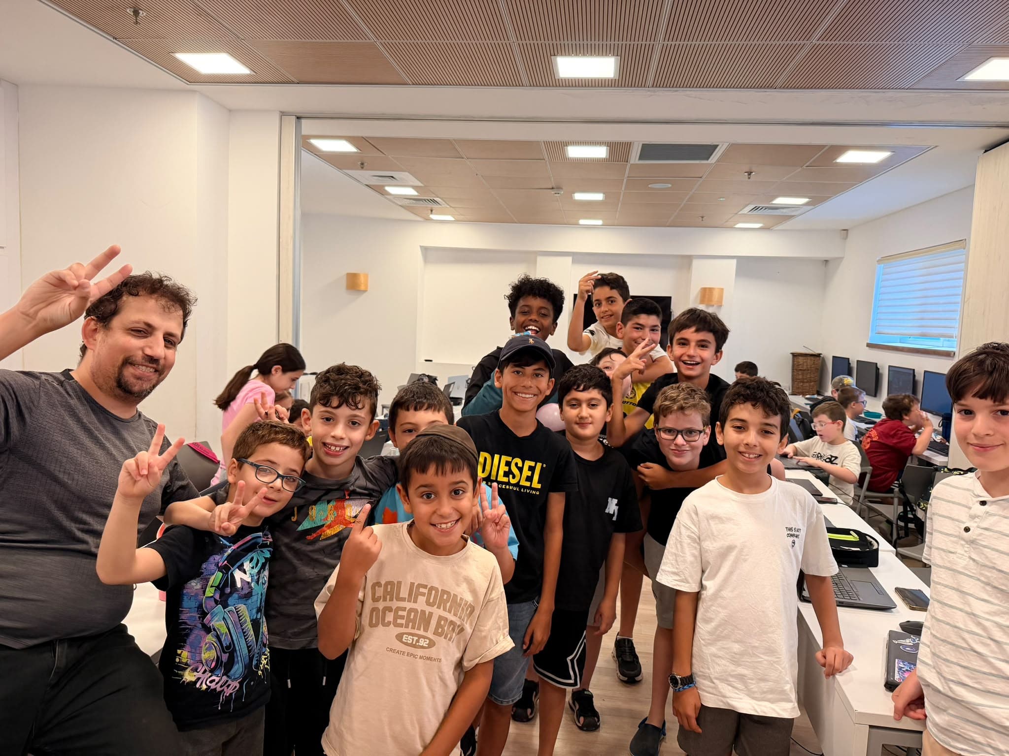 תלמידים מחייכים בכיתת המחשבים